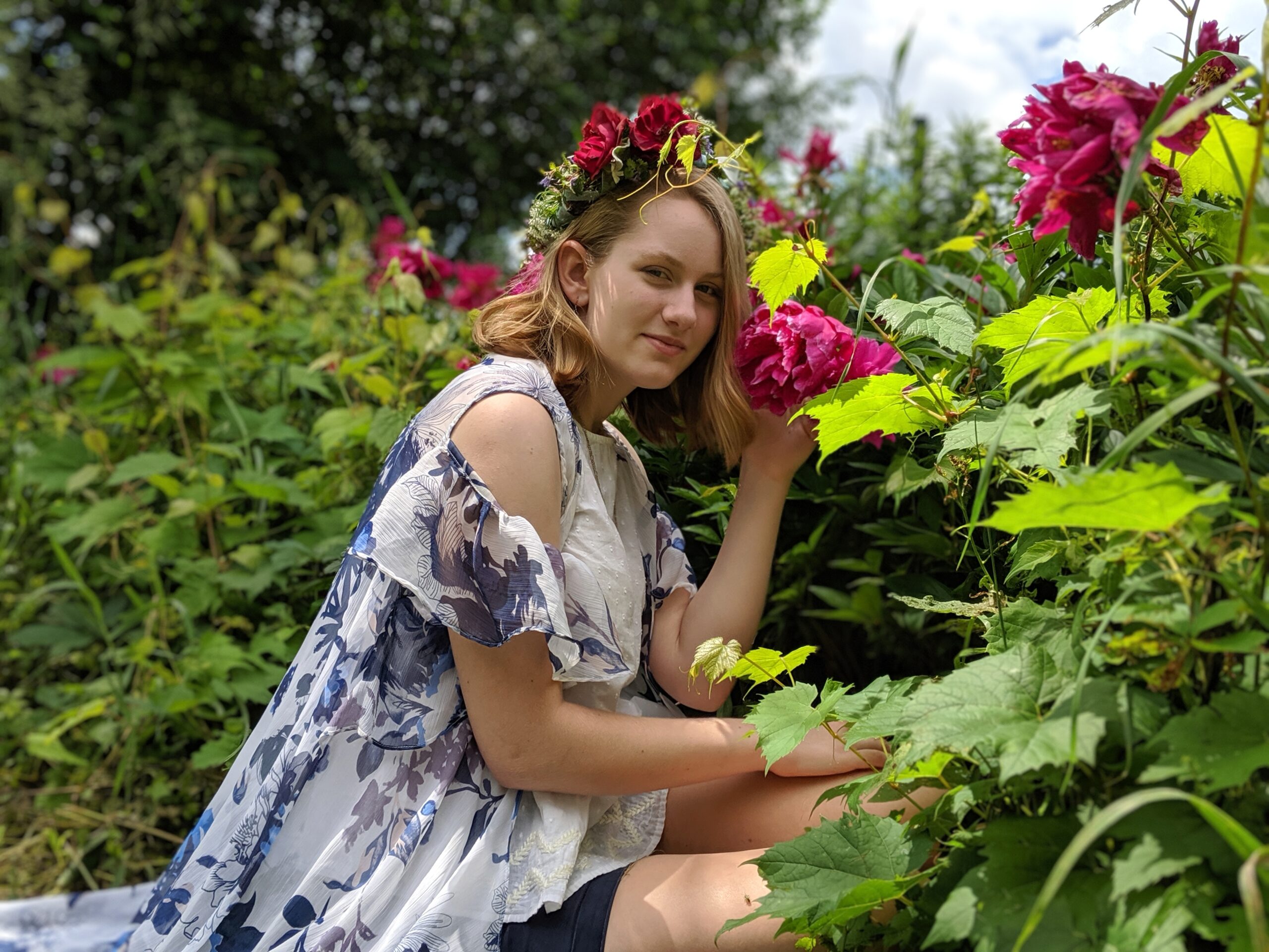 Artist profile picture in garden with pink flowers