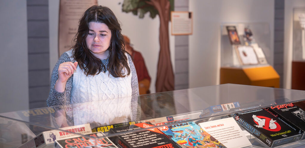 Woman looking at Dungeons and Dragons artifacts