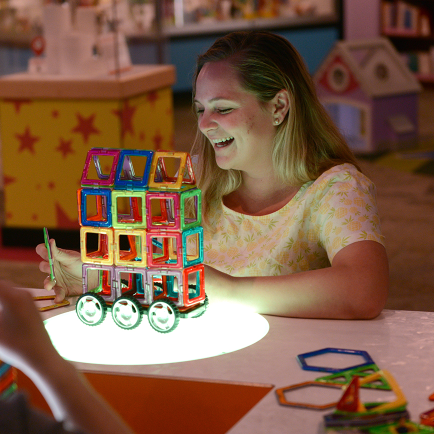 Women building light table structure at Happiest Hour